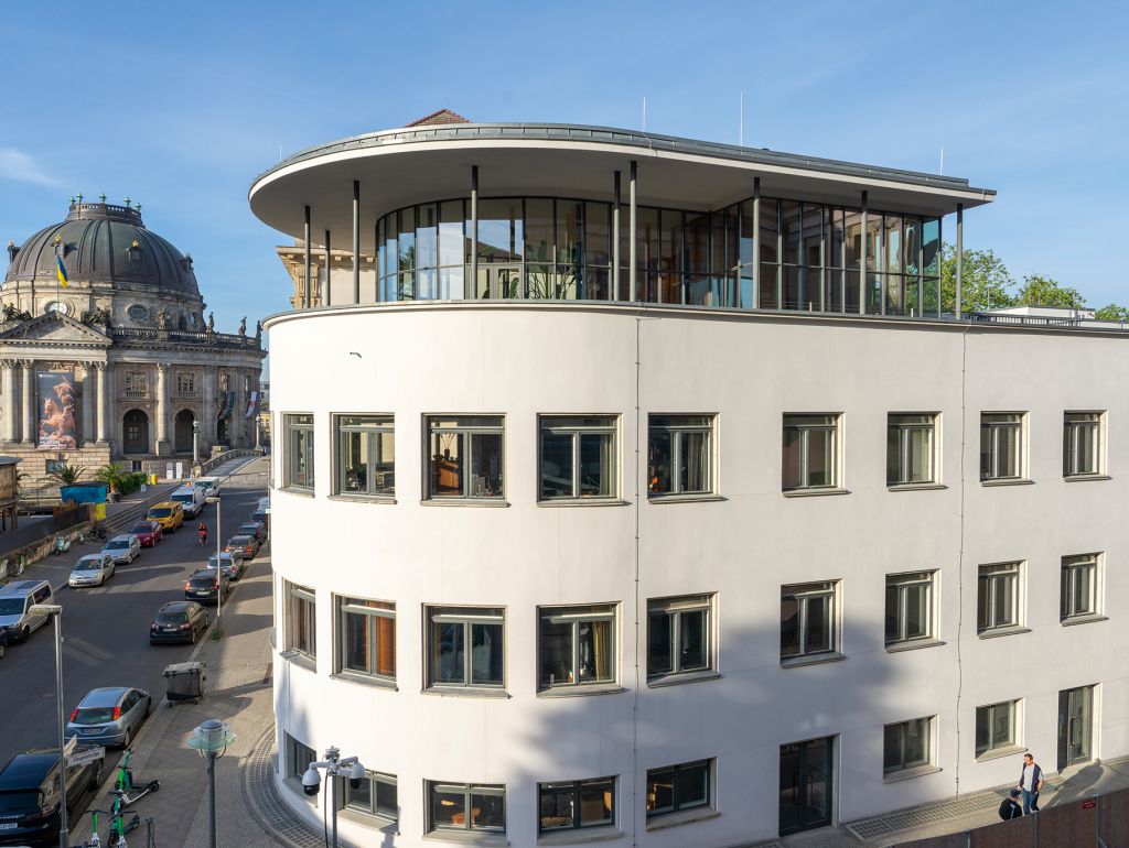 Haus im Bauhausstil. Im Hintergrund sieht man den Bundestag.