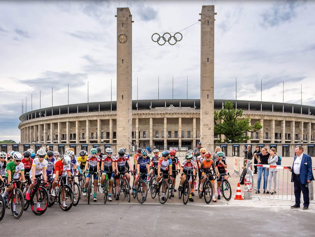 Eine Gruppe von Kindern auf Fahrrädern und in Fahrradkleidung wartet auf den Start des Rennens 