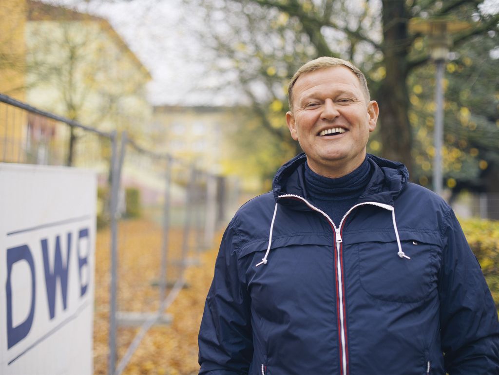 Foto von Dennis Wisbar neben einem Bauzaun