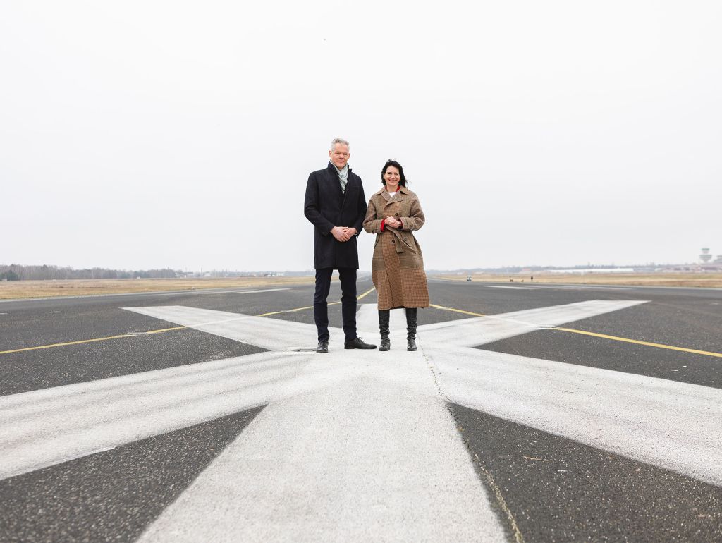 Zwei Personen auf der Start- und Landebahn Tegels