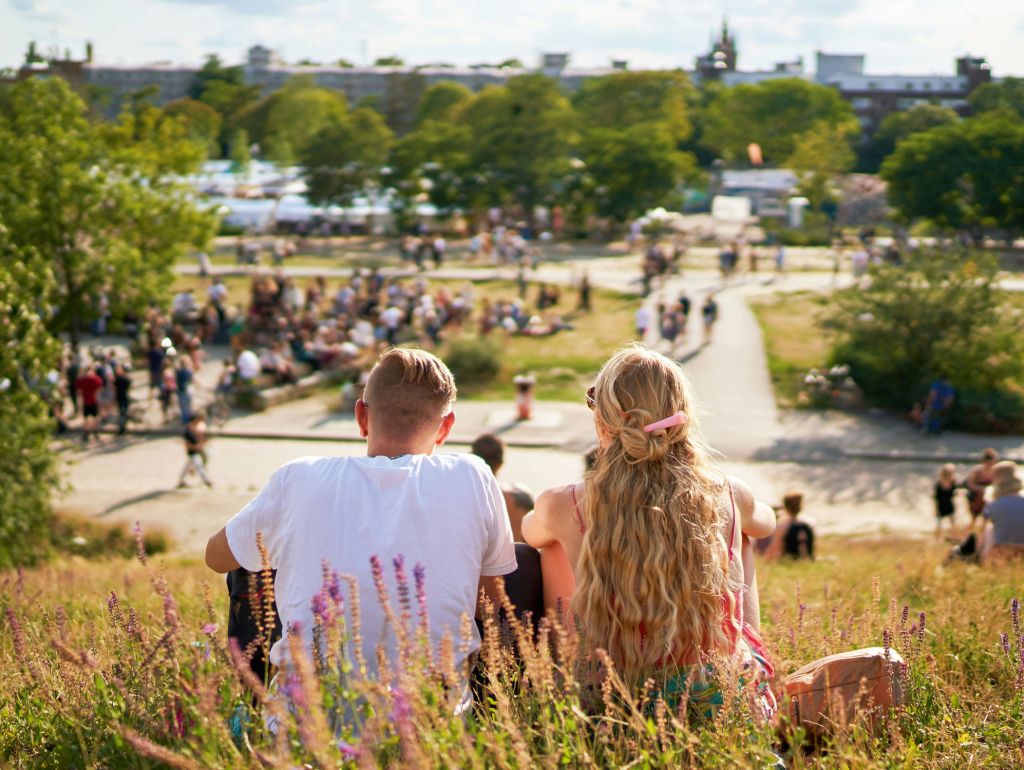 Ein Pärchen sitzt im Berliner Mauerpark auf einer Wiese