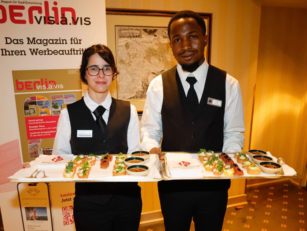 Zwei Mitarbeiter präsentieren Essen beim Frühlingsfest im Berlin Capital Club