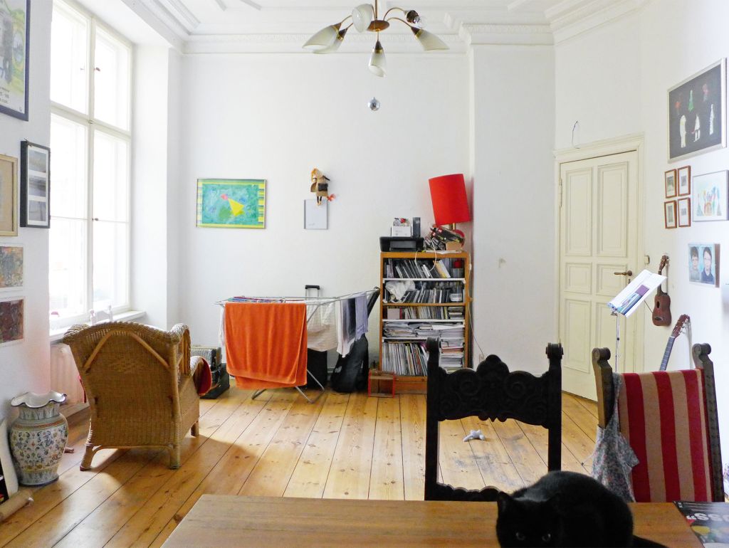 Blick in Zimmer, Regal, Wäschetrockner, Sessel, vordergrund Tisch mit stuhl