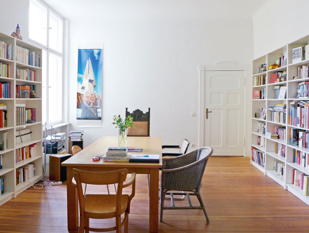 Zimmer, Hell wände voll mit Bücherschränken, mitte Tisch lang mit untersch. Stühlen