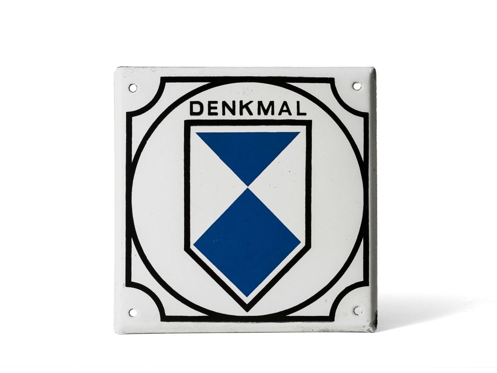 Bild von Plakette, die weiss mit blauen und schwarzen geometrische Figuren ist