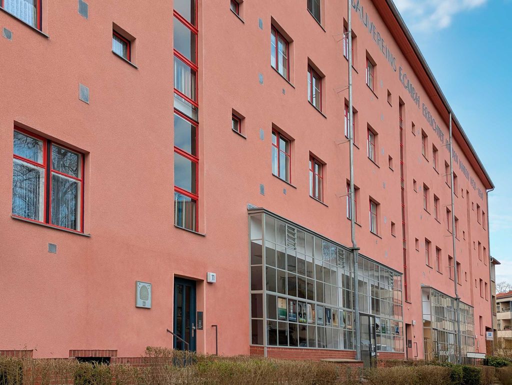 Orangene Hausfassade mit aufgemaltem Text 