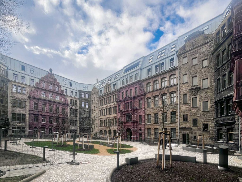 Innenfassade im Hof Bäume und Kopfsteinpflasterweg