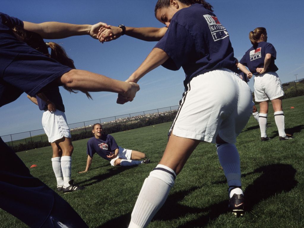 Frauen Fußball-Outfits machen Dehnungsübungen Draußen.