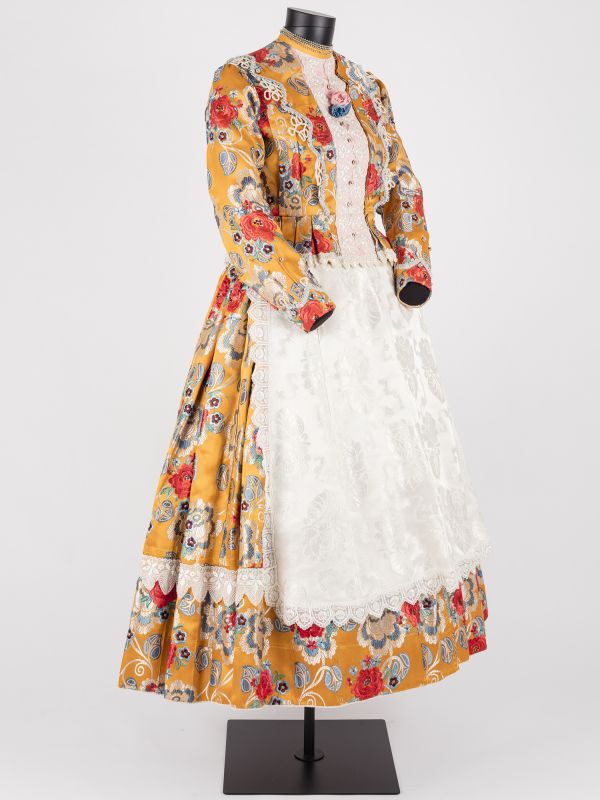 Tracht in Orange und Gelb mit weißer Schürze