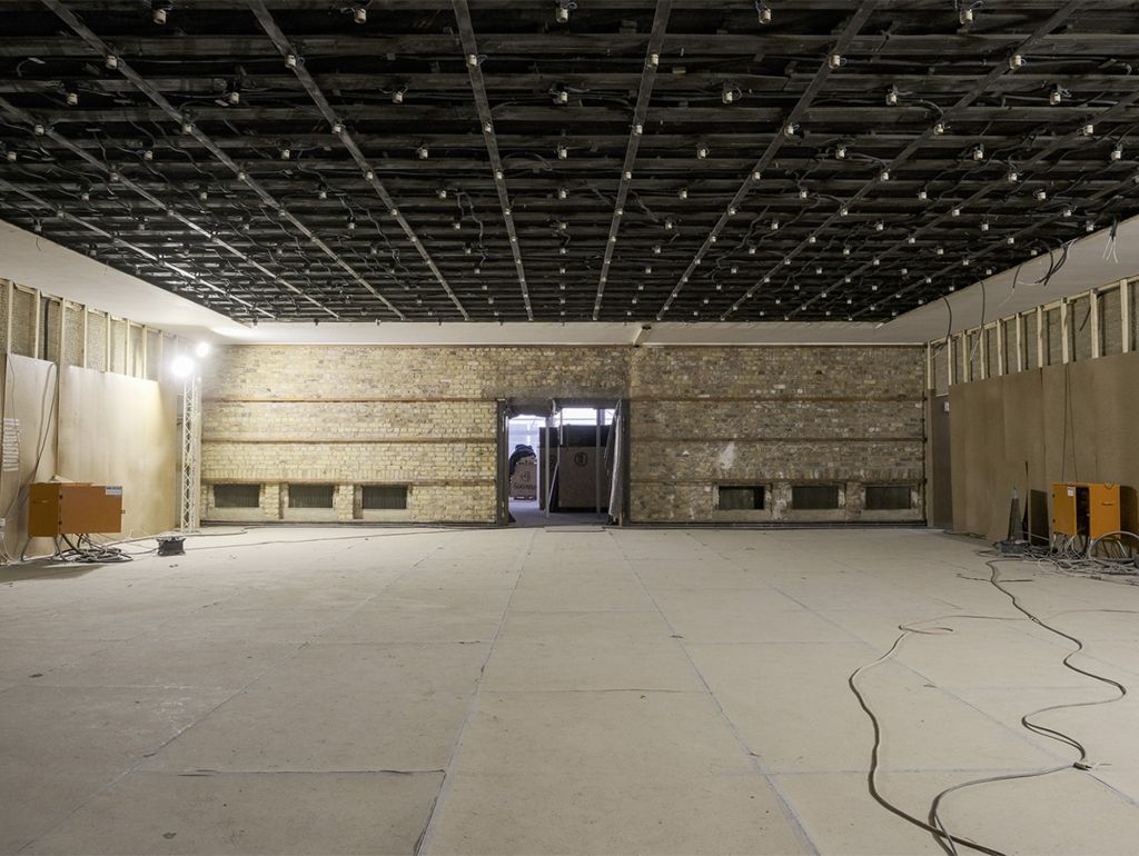 Die restaurierte ‚Golddecke‘ im Eingangsbereich sowie die Treppenhalle mit freigelegtem Mauerwerk