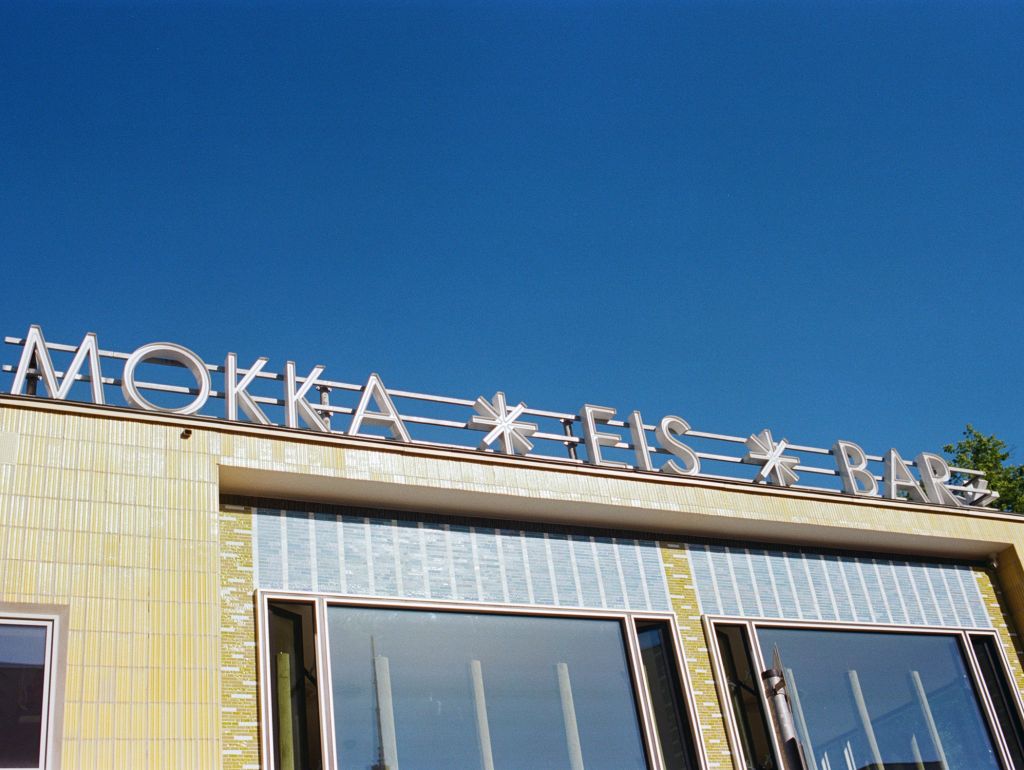 Fassadenansicht der „Mokka EIS BAR“ bei blauem Himmel.