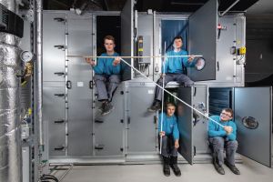 Vier Jugendliche Azubis posieren vor Metallschränken