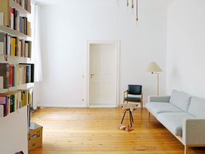 Berliner Zimmer mit bücherregal,sofa und einem stuhl