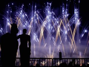 Feuerwerk in Lila im Vordergrund schatten von einem Pferd und einem Menschen