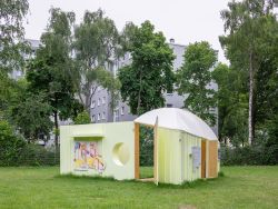 Maximilian Baumgartners Kunstwerk. Eine Ecke aus Holz vor einem Wohnhaus